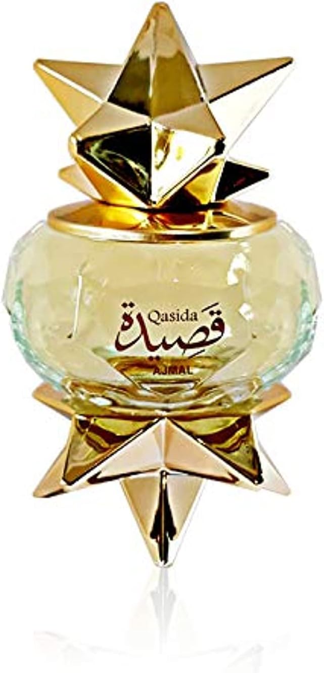 A decorative 60ml AJMAL QASIDA EAU DE PARFUM FOR MEN & WOMEN bottle features gold star accents and Arabic-English text on its clear, round glass body—a unisex fragrance that embodies elegance and artistry.